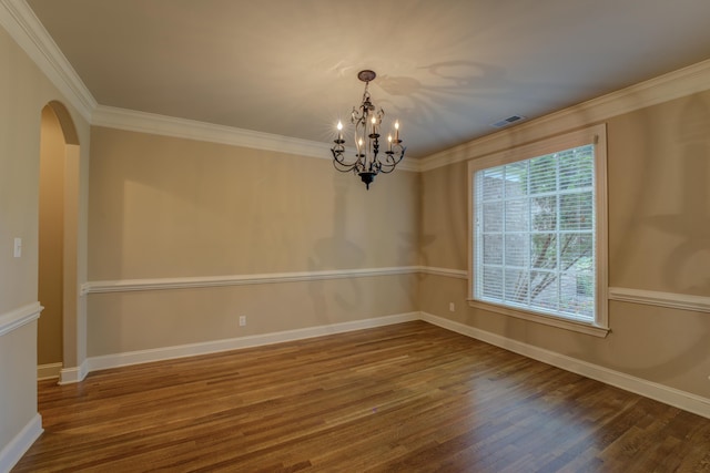 spare room featuring ornamental molding, a notable chandelier, and hardwood / wood-style floors