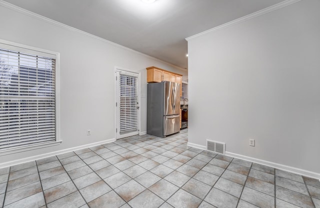 tiled spare room featuring crown molding