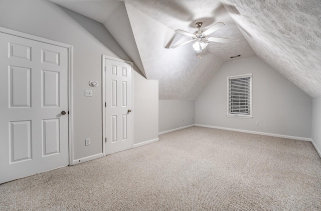 bonus room with vaulted ceiling, a textured ceiling, ceiling fan, and carpet