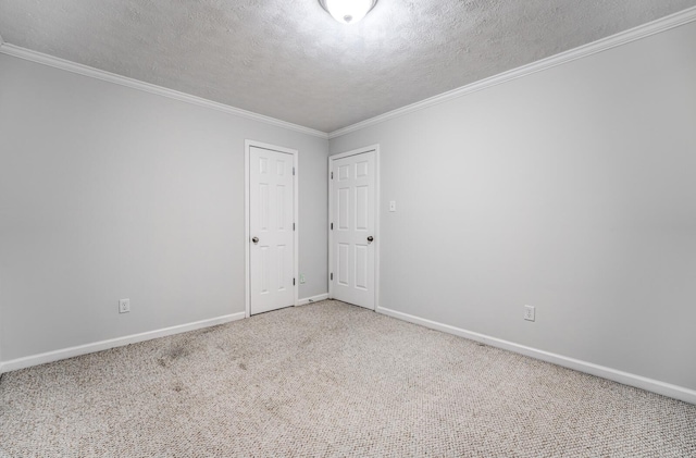 carpeted spare room featuring a textured ceiling and ornamental molding