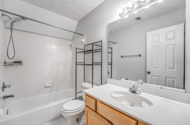 full bathroom featuring toilet, a textured ceiling, tile patterned floors, tiled shower / bath, and vanity