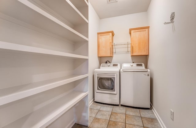 washroom featuring washing machine and dryer and cabinets