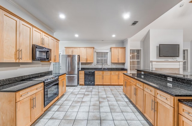 kitchen with dark stone countertops, black appliances, ornamental molding, light brown cabinetry, and sink