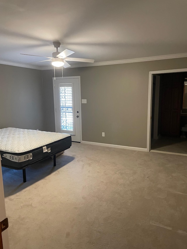 unfurnished bedroom featuring carpet flooring, ceiling fan, and crown molding