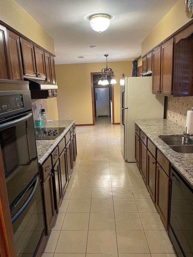 kitchen with black appliances, light stone countertops, pendant lighting, sink, and light tile patterned flooring