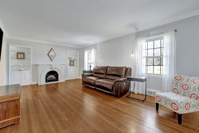 living room with hardwood / wood-style flooring, built in features, and ornamental molding