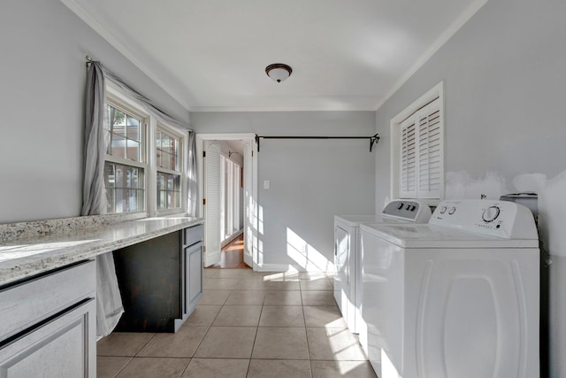 washroom with crown molding, washer and dryer, and light tile patterned floors