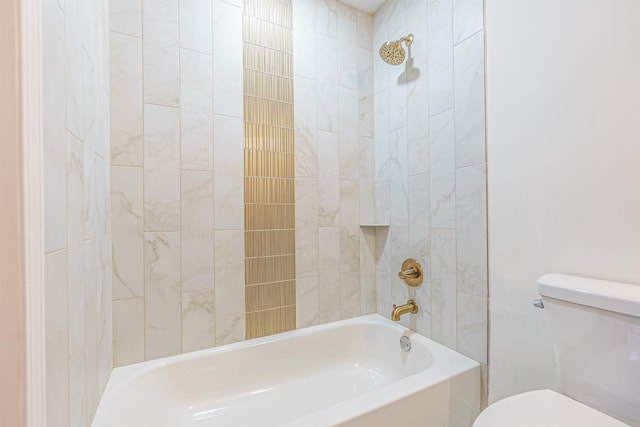 bathroom featuring tiled shower / bath combo and toilet