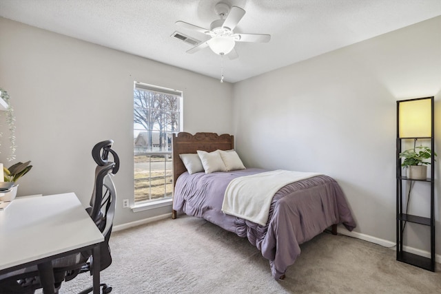 bedroom with a textured ceiling, ceiling fan, light carpet, and multiple windows