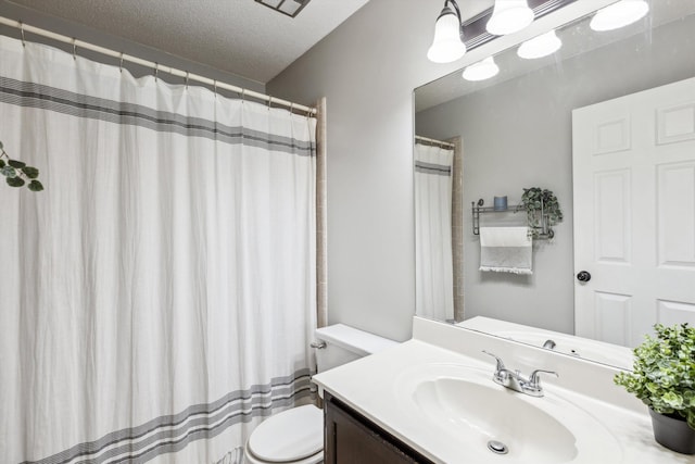 bathroom featuring a textured ceiling, curtained shower, vanity, and toilet