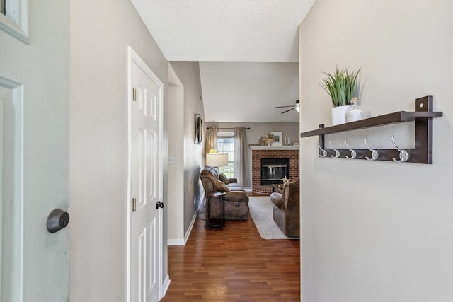 corridor with dark hardwood / wood-style flooring and a textured ceiling