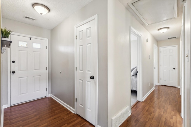 foyer entrance featuring a textured ceiling and dark hardwood / wood-style flooring