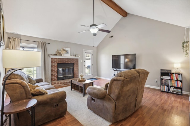 living room with beam ceiling, dark wood-type flooring, a fireplace, and ceiling fan