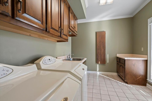 clothes washing area with light tile patterned floors, cabinets, separate washer and dryer, ornamental molding, and sink