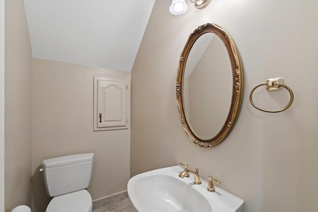 bathroom featuring sink, vaulted ceiling, and toilet