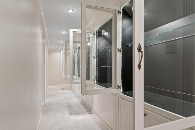 hallway featuring crown molding and light carpet