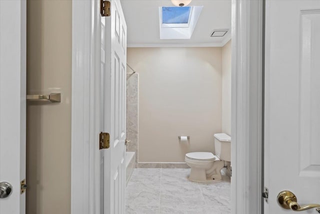 bathroom featuring a skylight, crown molding, washtub / shower combination, and toilet