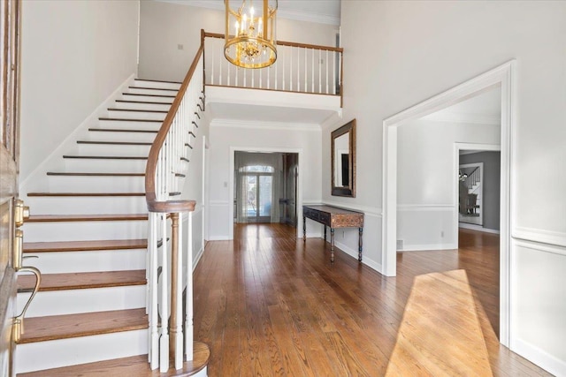 foyer featuring a notable chandelier, crown molding, and wood-type flooring