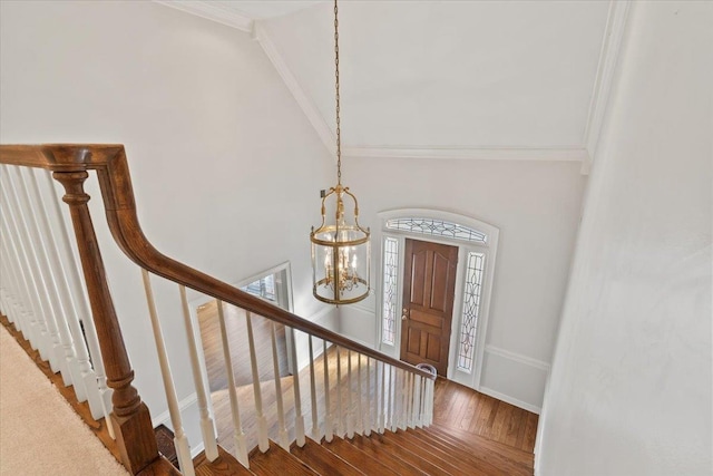 stairway with ornamental molding and a chandelier