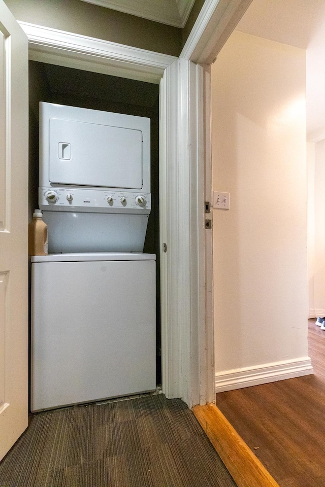 laundry area with stacked washer / dryer and crown molding