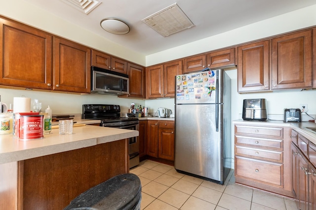 kitchen featuring appliances with stainless steel finishes and light tile patterned floors