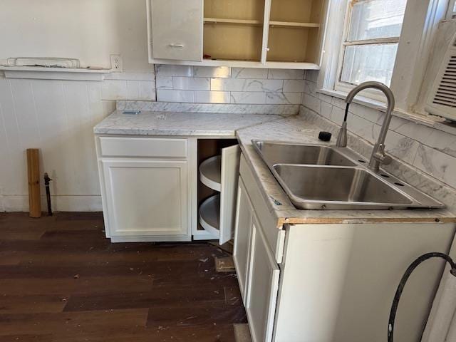 kitchen with white cabinetry, dark wood-type flooring, sink, and light stone counters