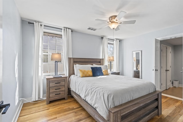 bedroom featuring ceiling fan, light wood-type flooring, and ensuite bathroom