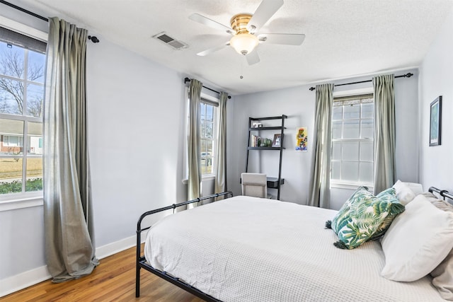 bedroom with wood-type flooring, a textured ceiling, and ceiling fan