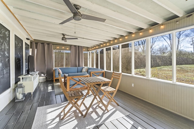 sunroom featuring ceiling fan and beam ceiling