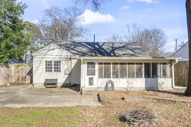 rear view of house featuring a patio area and a sunroom