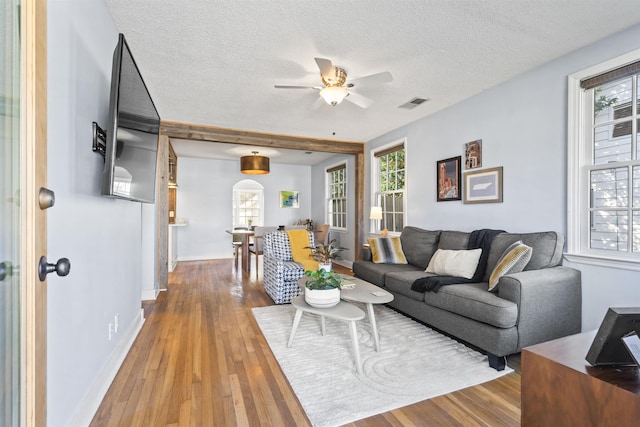 living room with ceiling fan, hardwood / wood-style floors, and a textured ceiling