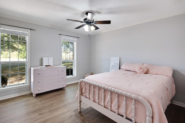 bedroom with a textured ceiling, ceiling fan, crown molding, and light hardwood / wood-style flooring