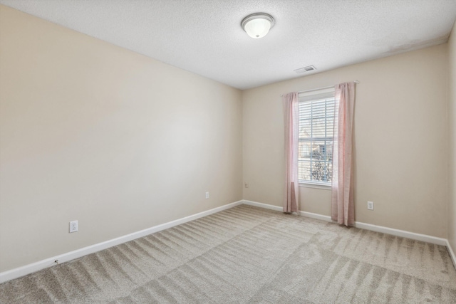 carpeted empty room featuring a textured ceiling