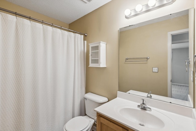 bathroom featuring a textured ceiling, vanity, and toilet