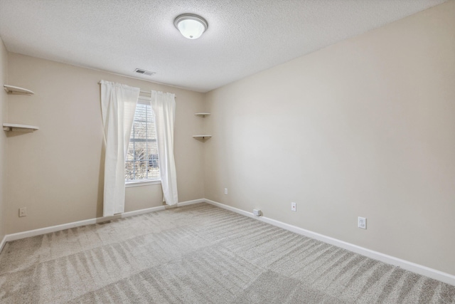 unfurnished room featuring a textured ceiling and carpet floors