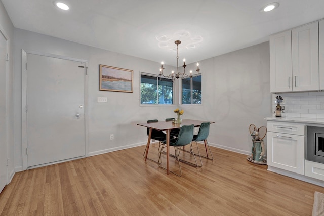 dining area with a notable chandelier and light hardwood / wood-style flooring