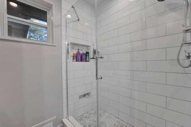 bathroom featuring a shower with door