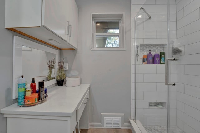 bathroom featuring walk in shower and vanity