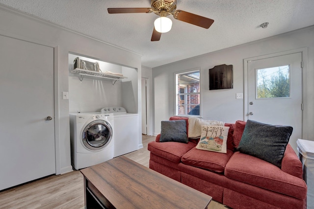 washroom with a textured ceiling, ceiling fan, light hardwood / wood-style flooring, and independent washer and dryer