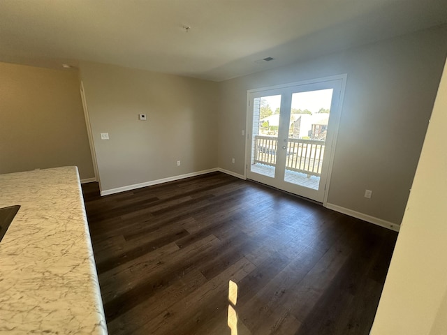 empty room featuring dark hardwood / wood-style flooring and french doors