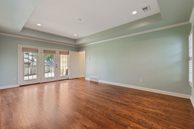 unfurnished room with hardwood / wood-style flooring, a tray ceiling, and ornamental molding