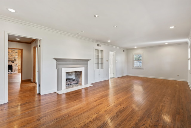 unfurnished living room with ornamental molding, built in features, and wood-type flooring