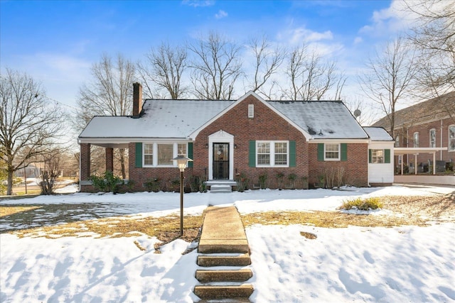 view of front of property featuring brick siding and a chimney