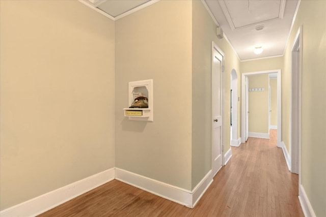 corridor featuring ornamental molding and light hardwood / wood-style flooring