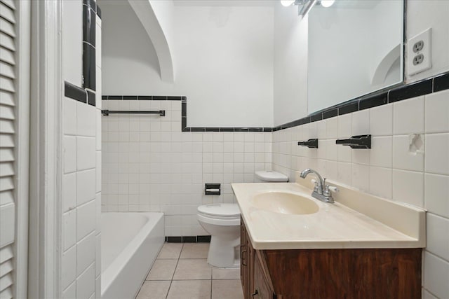 bathroom with toilet, tile walls, tile patterned floors, a bath, and vanity