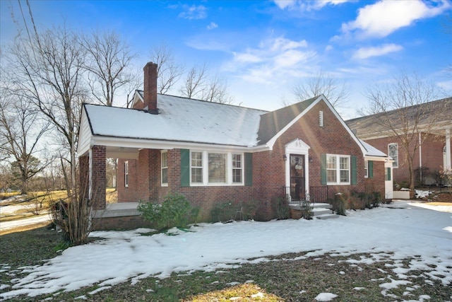 view of front facade with brick siding and a chimney