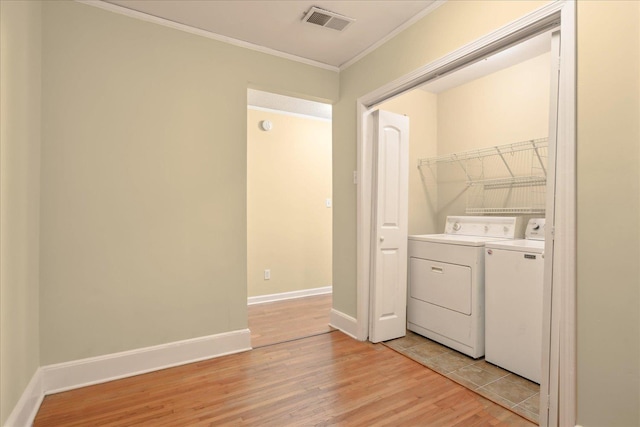 washroom featuring washer and dryer, ornamental molding, and light hardwood / wood-style floors