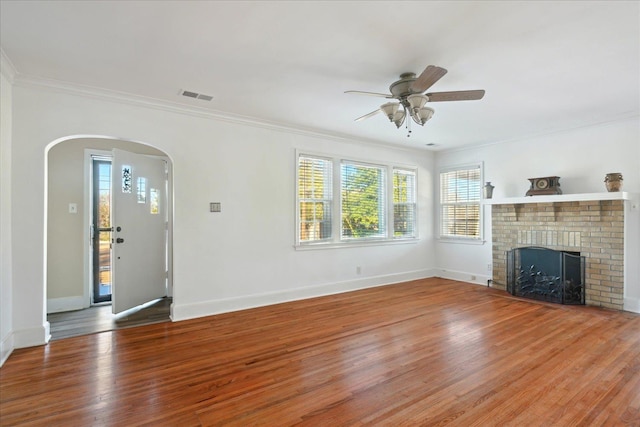 unfurnished living room featuring ornamental molding, a fireplace, and hardwood / wood-style flooring