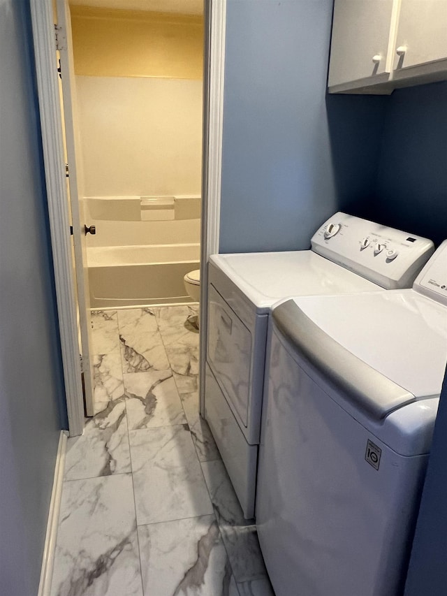 laundry room featuring washer and clothes dryer and cabinets