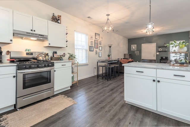 kitchen featuring white cabinetry, stainless steel gas range oven, dark hardwood / wood-style floors, pendant lighting, and a notable chandelier